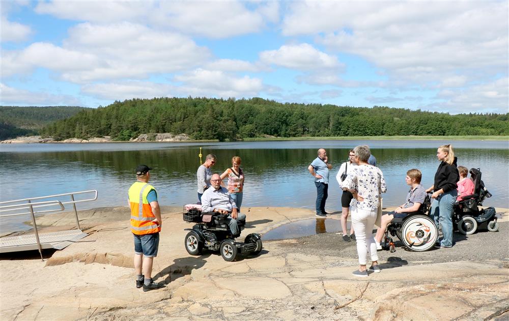Bilde av rullestolbrukere og representanter fra Halden kommune ved baderampen på Ystehedeneset. - Klikk for stort bilde