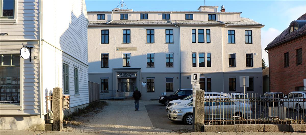 Bygning i fire etasjer, hvite vegger.  - Klikk for stort bilde