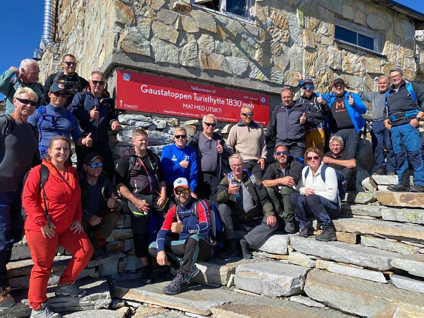 21 ansatte i kommunalteknikk ved skiltet hvor det står Gaustatoppen turisthytte. Foto. - Klikk for stort bilde