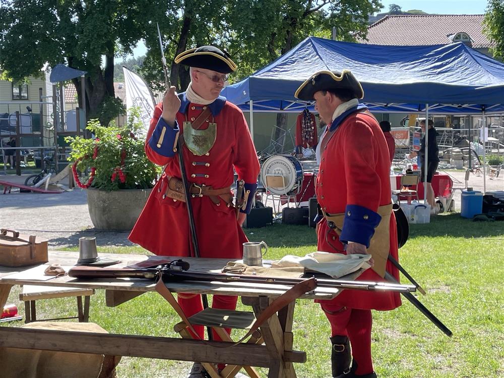 Fredriksten Artillerie Compagnie er en militærhistorisk og aktiv forening med ca. 60 medlemmer. Fredriksten Artillerie compagnie gjenskaper historiske hendelser i samarbeid med andre, og har flere ganger gjenskapt da Karl XII angrep Fredriksten. De er lette å kjenne igjen med sine røde uniformer og har ofte salutter fra Fredriksten Festning.  Opprinnelig skulle de ha en salutt med musketter kl. 11.00, men den måtte vi dessverre avlyse grunnet forbudet om åpen ild.  - Klikk for stort bilde