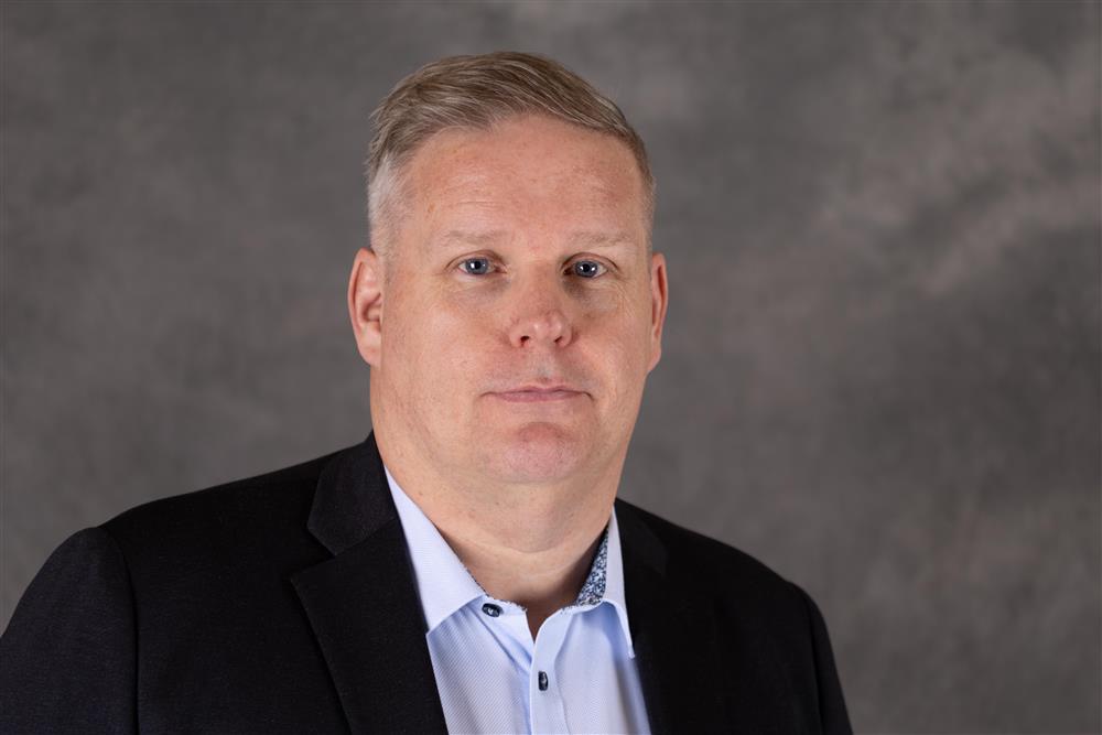 Mann med kort lyst hår står foran en grå bakgrunn - Klikk for stort bilde