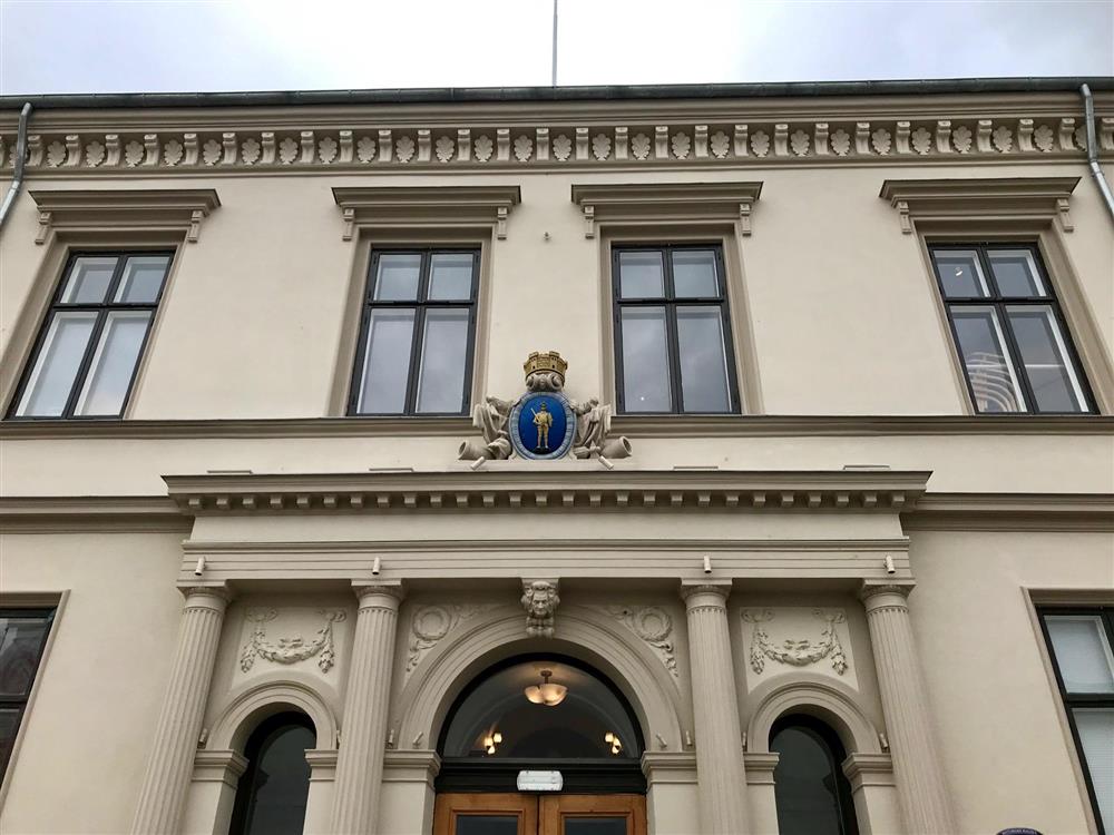 Bilde av hovedinngangen til Halden rådhus og byvåpenet over døren. - Klikk for stort bilde