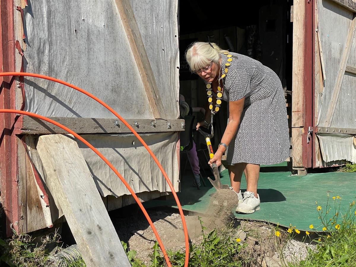 Bilde av ordfører Anne-Kari Holm som graver fiberkabel på Gribsrød gård i Enningdalen - Klikk for stort bilde