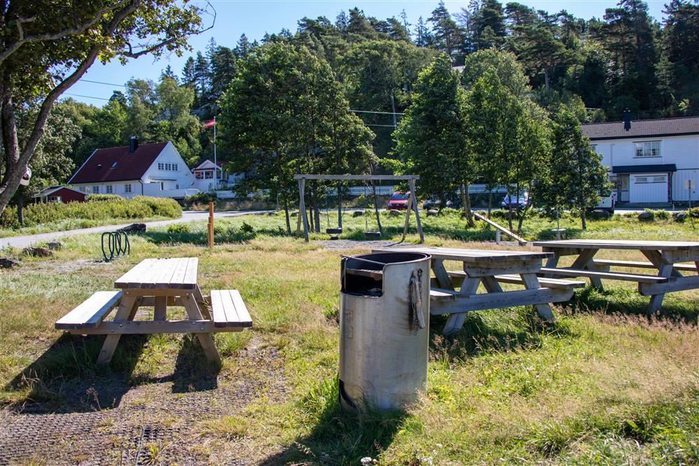Trebenker som står sammen med en metallgrill på en gressplen - Klikk for stort bilde