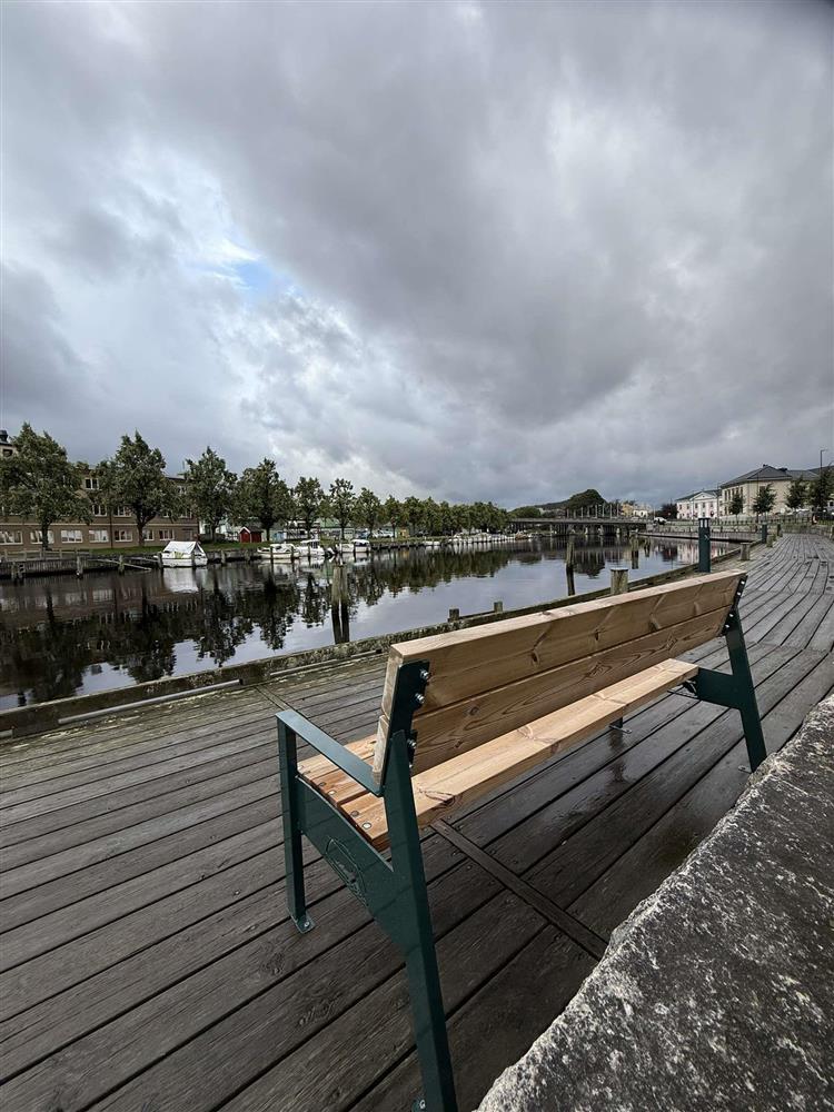 Benk plassert på brygge ved elva - Klikk for stort bilde